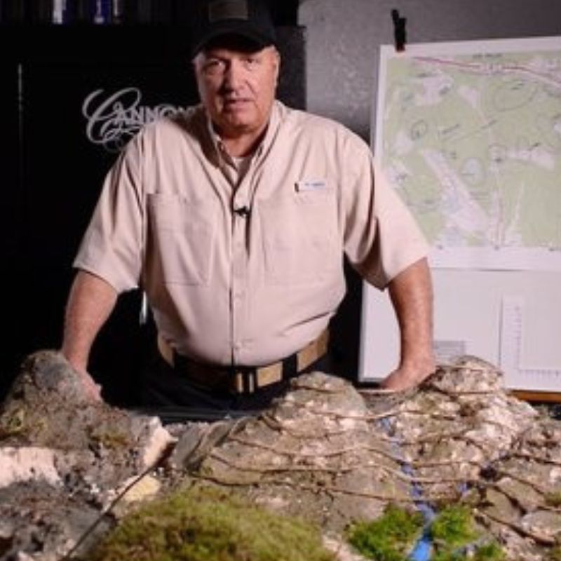 Land Navigation DVD or USB showing instructor with terrain model and map, featuring custom kit builds and service A Way Through the Wilderness